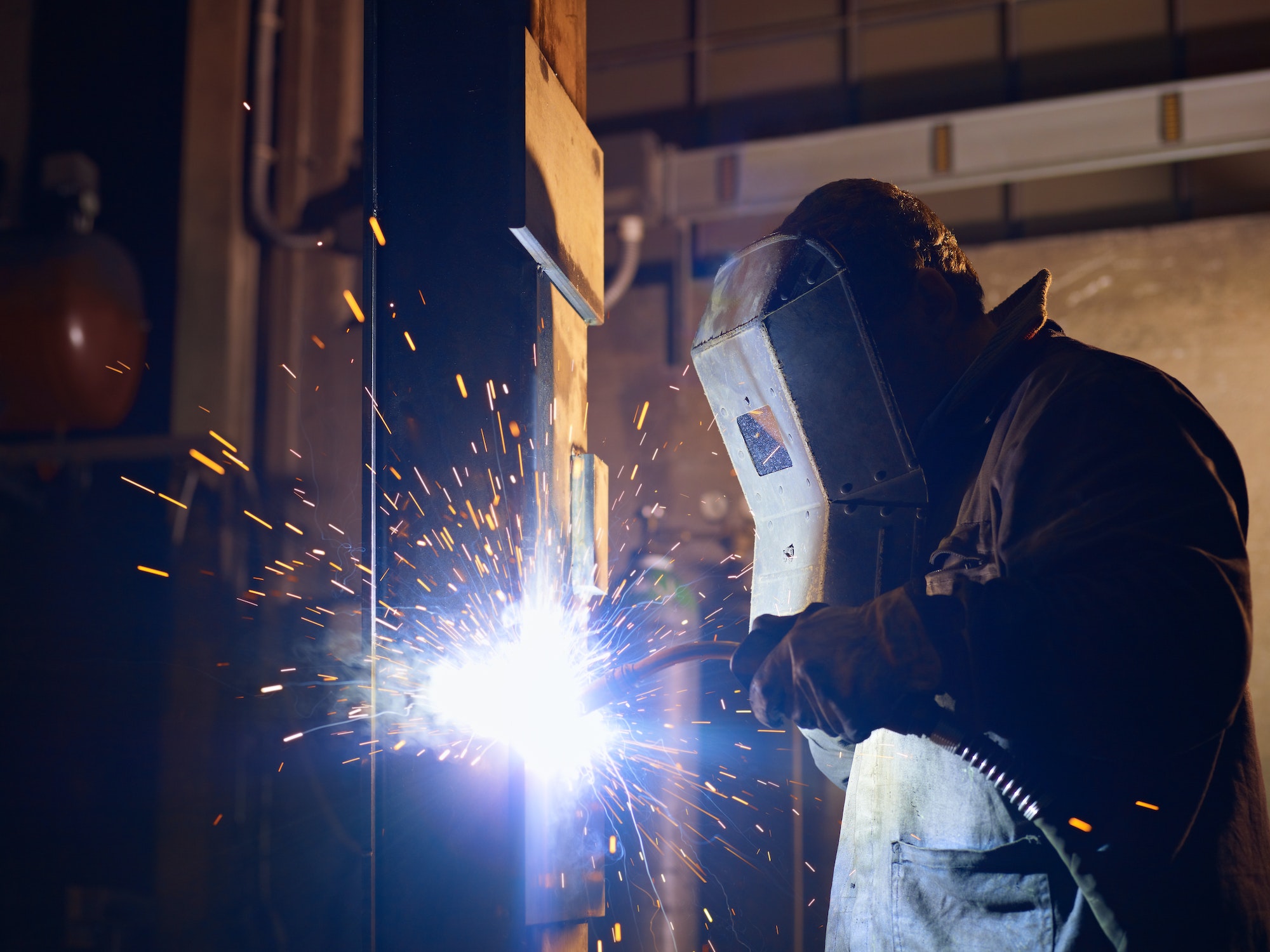 Man at work as welder in heavy industry